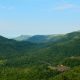 A stunning view of green picturesque mountains under the blue clear sky